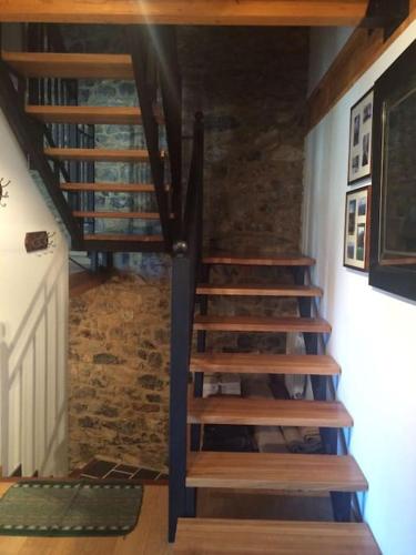 a wooden staircase in a room with a brick wall at La casa de Juan el Cantero in Puebla de Lillo