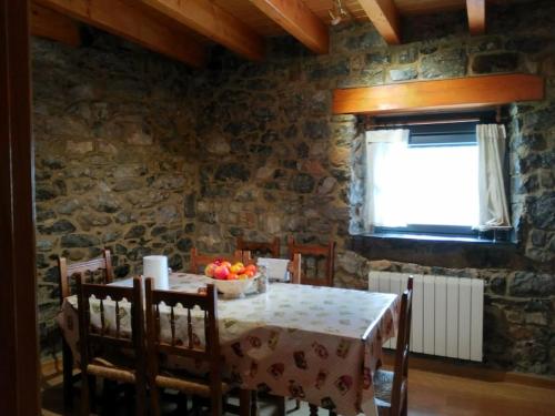 a dining room with a table with a bowl of fruit on it at La casa de Juan el Cantero in Puebla de Lillo
