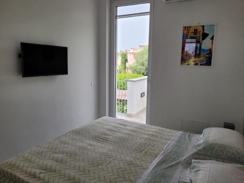 a bedroom with a bed and a flat screen tv at Cozy Corner Apartment Forio in Forio d'Ischia
