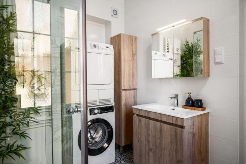 a bathroom with a washing machine and a sink at Infinite Residences - Central Location, Tradition and Comfort in Corfu Town