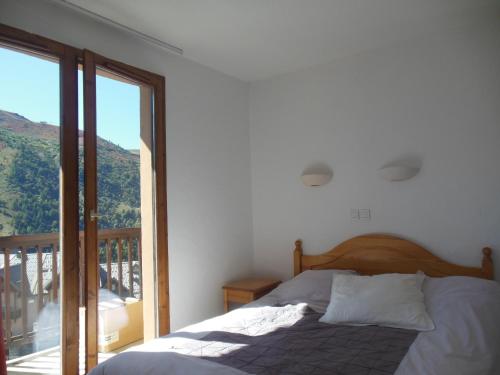 une chambre avec un lit et une grande fenêtre dans l'établissement APPARTEMENT STATION HAUTE MONTAGNE Savoie, à Le Désert
