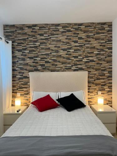 a bedroom with a bed with two red and black pillows at Silver House 96 ideal parejas in Arrecife