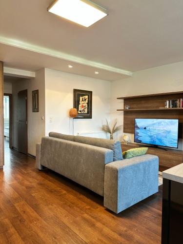 Una sala de estar con un sofá y un televisor de pantalla plana. en Comfy Stay Apartment, en Trenčín