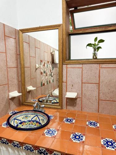 a bathroom with a sink and a mirror at Posada El Palomar in Pátzcuaro