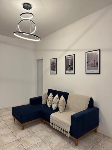 a living room with a blue couch with pillows at Viva a bela Copacabana! in Rio de Janeiro
