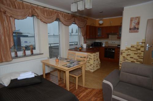 a kitchen and living room with a table and a couch at Apartament Classic in Szczecin