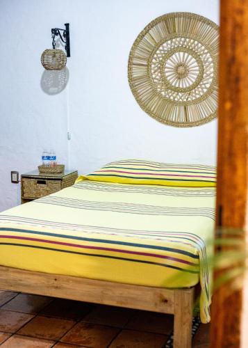 a bedroom with a bed and a fan on the wall at Posada El Palomar in Pátzcuaro