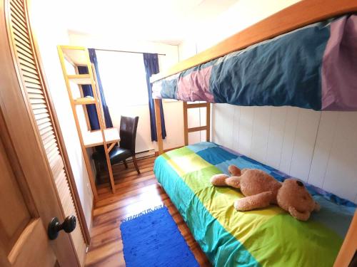 a teddy bear laying on a bed in a bedroom at Maison au Pied du Mont Video in Barraute
