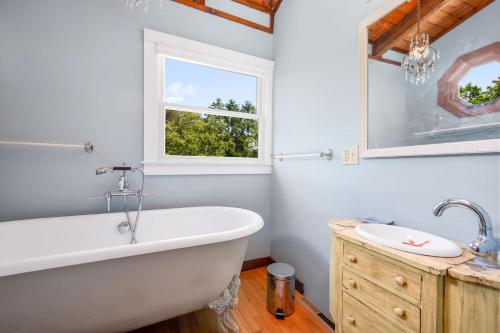 eine weiße Badewanne in einem Badezimmer mit Fenster in der Unterkunft 2 Bayberry Road Harwich Port Cape Cod - Cranberry Cottage in Harwich Port