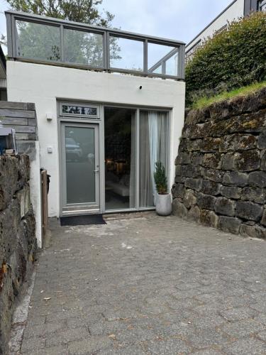 a house with a glass door and a stone wall at Studio apartment in central Reykjavik in Reykjavík