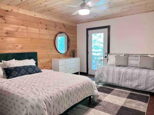1 Schlafzimmer mit 2 Betten und einer Holzwand in der Unterkunft Close to Lake Blue Ridge, Hot Tub, Swing Beds in Morganton