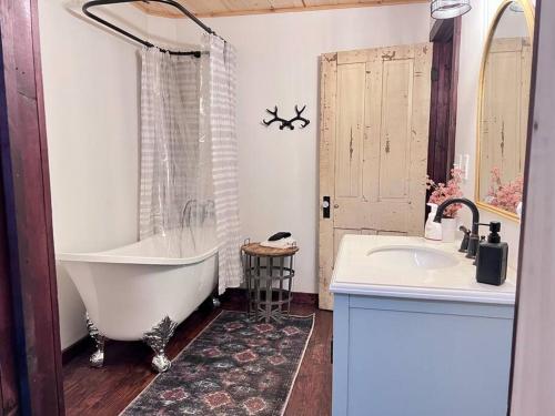 ein Badezimmer mit Badewanne und Waschbecken in der Unterkunft Close to Lake Blue Ridge, Hot Tub, Swing Beds in Morganton