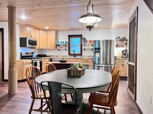 a kitchen with a table and chairs and a refrigerator at Close to Lake Blue Ridge, Hot Tub, Swing Beds in Morganton