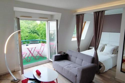 Cette chambre d'hôtel dispose d'un lit, d'un canapé et d'une terrasse. dans l'établissement Denier étage avec Parking, à La Garenne-Colombes