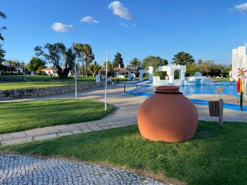 a large pot sitting on the grass in a park at Studio Pedras del Rei - Casa Verde in Tavira
