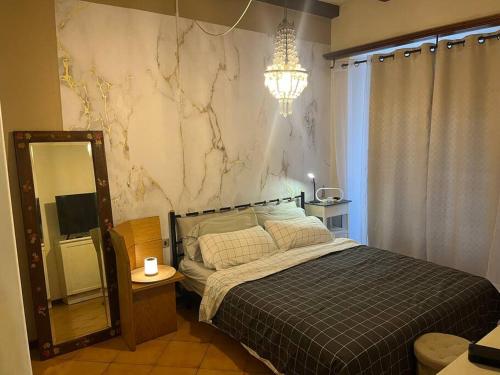 a bedroom with a bed and a mirror and a chandelier at Benedetta in Chiavenna