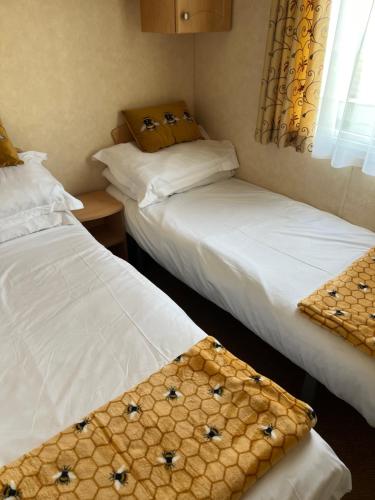 two twin beds in a room with a window at 613 Promenade, Ingoldmells in Ingoldmells