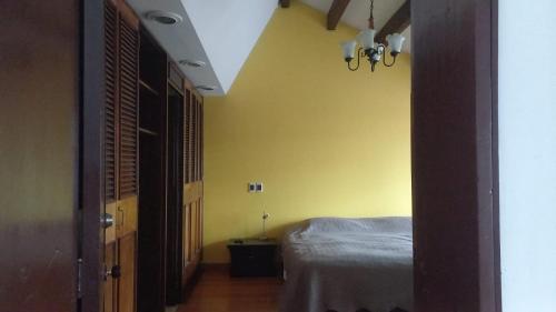 a bedroom with a bed and a yellow wall at Apartamento en Chicó Norte in Bogotá