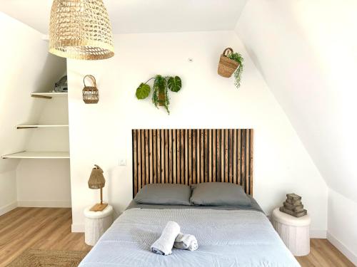 une chambre avec un lit avec une tête de lit en bois dans l'établissement Caporizon-Les Balançoires de Sarlat, à Sarlat-la-Canéda