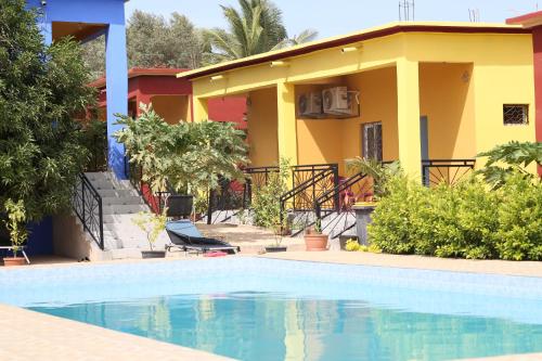 una casa con piscina delante en Residence le Belier, en Mbirdiamm