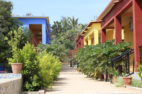 una pasarela entre dos edificios con plantas en Residence le Belier, en Mbirdiamm