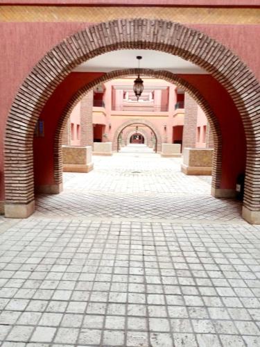 an archway in a building with a brick sidewalk at Beautiful Hivernage Apartment with Pool & Balcony, Near Attractions in Marrakech