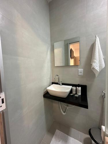 a bathroom with a sink and a mirror at Torre Hotel in Jaguaquara