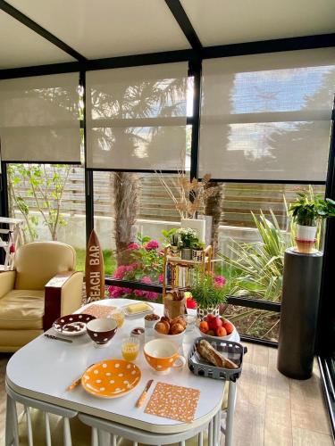 - une table avec de la nourriture dans une chambre avec des fenêtres dans l'établissement Au Renard Baulois - chambre d'hôtes, à La Baule
