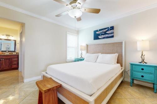 a bedroom with a white bed and a blue nightstand at Fortuna Sea Brisas Condominiums #4 in Corpus Christi