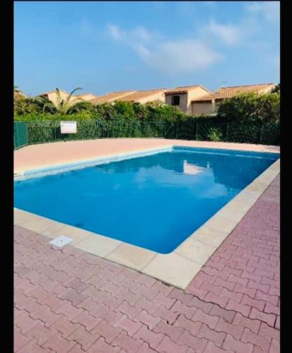 une piscine avec de l'eau bleue dans une cour dans l'établissement Appartement mezzanine au bord de la lagune, à Saint-Cyprien