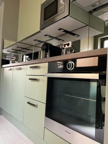 une cuisine avec une cuisinière et un micro-ondes dans l'établissement Petite maison centre ville châteaudun, à Châteaudun