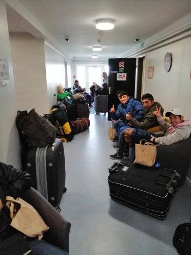 a group of people sitting in a waiting room with luggage at The Lodges in Stanley