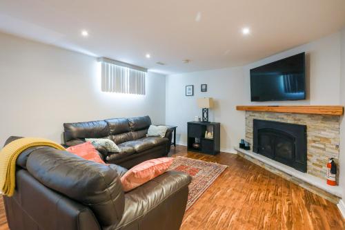 a living room with a leather couch and a fireplace at 1,200sq ft comfy home, perfect location, luxury bedding, feels like home! in Mississauga
