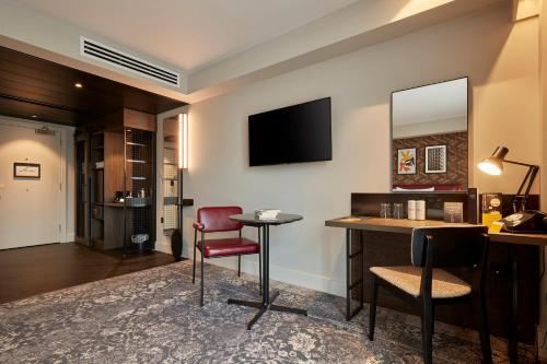 a hotel room with a desk and a mirror at voco Leicester by IHG in Leicester