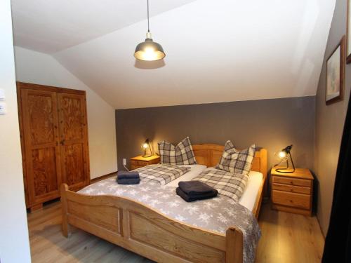 a bedroom with a large wooden bed with pillows at Haus zum Hirschen in Gnesau Sonnleiten