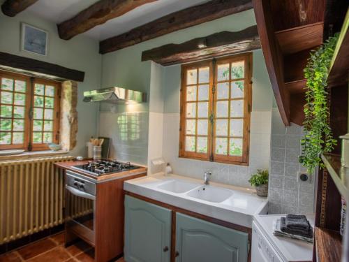 une cuisine avec un évier et une cuisinière dans l'établissement La belle Vie, à Urval