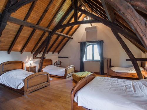 a bedroom with three beds in a room with wooden ceilings at Beauchamps in Marminiac