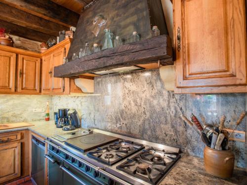 a kitchen with a stove top oven and wooden cabinets at Beauchamps in Marminiac