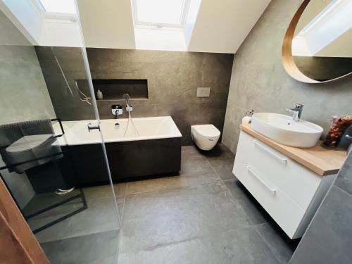 a bathroom with a sink and a tub and a toilet at Butter Chill House - Dom na Kaszubach in Masłowo