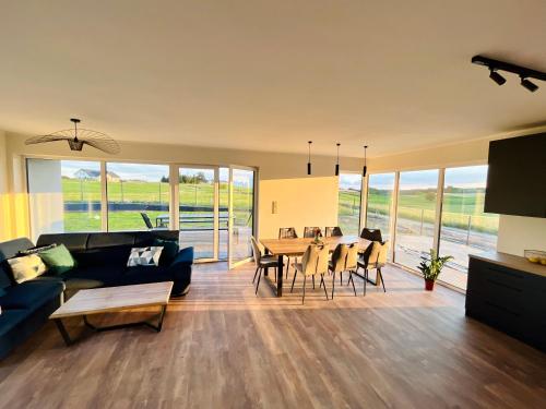 a living room with a couch and a table with chairs at Butter Chill House - Dom na Kaszubach in Masłowo