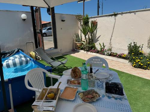 a white table with food on it in a backyard at Holiday Rome Hub Villa Camilla in Fiumicino