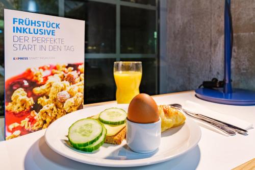 a plate of food with a egg and a drink at Holiday Inn Express Dresden Zentrum by IHG in Dresden