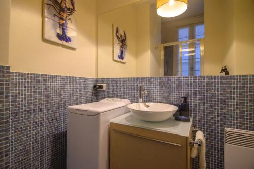 une salle de bain avec un lavabo, des toilettes et un miroir dans l'établissement Le Marais Moderne, à Paris