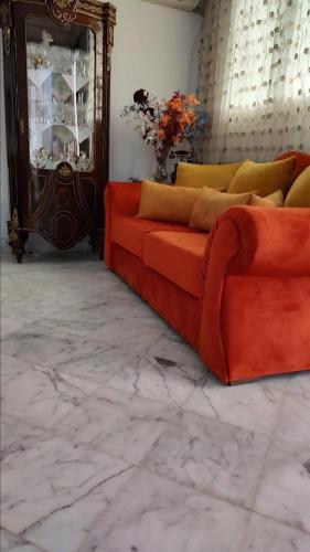 a living room with a red couch and a mirror at Guest house DAR Al YASMINA in Tunis