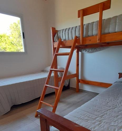 een slaapkamer met twee stapelbedden en een raam bij Cabañas Tinkuy I in Cortaderas