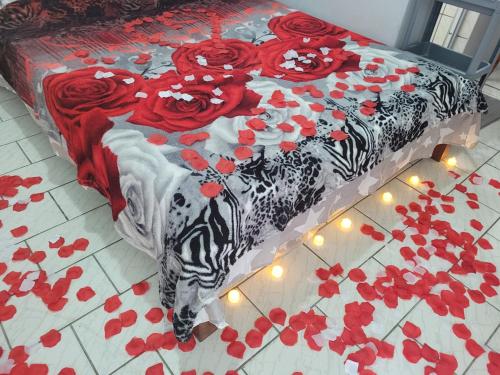 a bed with red roses on it with lights on the floor at Unidades 1 e 2 e 3 Pousada do Sossego Mar e Verde in Itanhaém