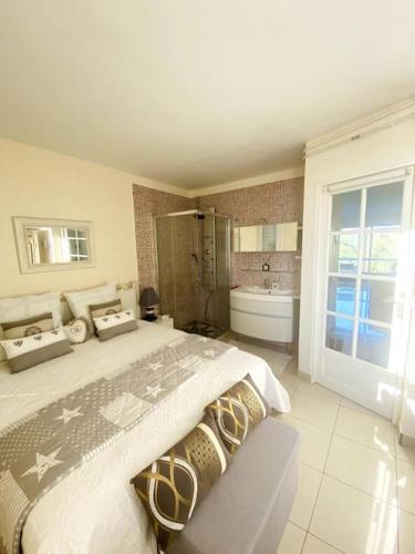une chambre avec un grand lit et une baignoire dans l'établissement Élégant appartement au Port de Saint-Cyprien, à Saint-Cyprien
