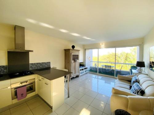 Il dispose d'une cuisine et d'un salon avec un canapé et une table. dans l'établissement Élégant appartement au Port de Saint-Cyprien, à Saint-Cyprien