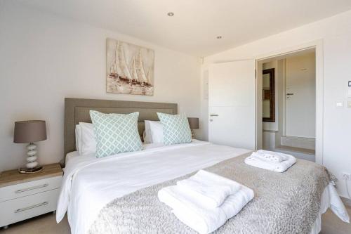 a bedroom with a large white bed with towels on it at Blue Views Villa with Heated Pool & Jacuzzi in Dubrovnik