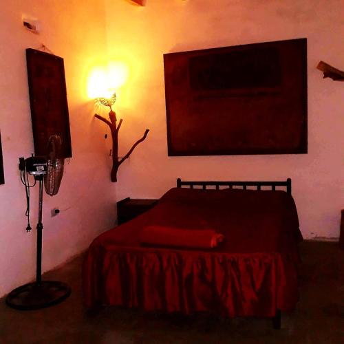 a bedroom with a red bed and a lamp at La Revuelta in Amaicha del Valle